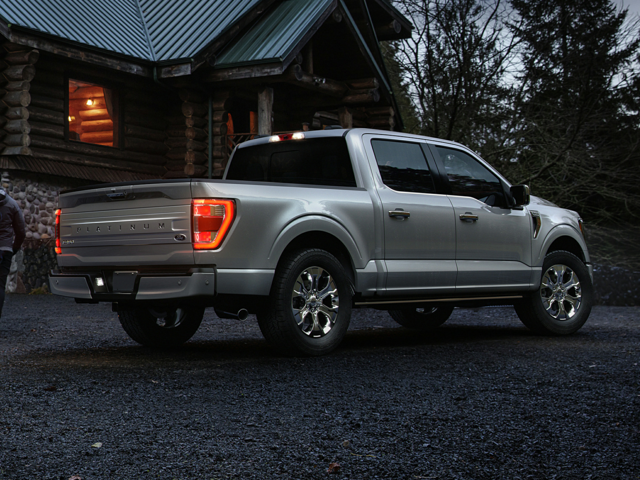 Silver 2024 Ford F-150 parked in front of a cabin in the woods. | Ford dealer in New Lexington, OH | Keer Automotive Ford